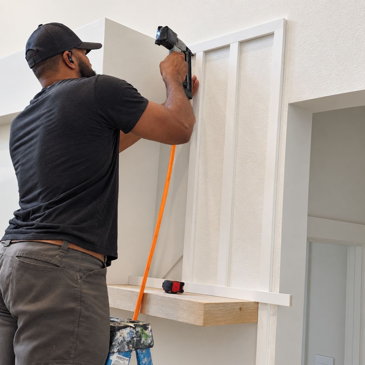 Jon Jon nailing board and batten trim above a white oak floating shelf